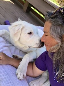 Stacy, the dog trainer, leans in to get a sniff from a client's big white puppy